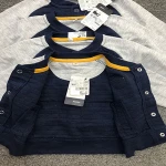 babyboy's V-neck cardigan /sweatshirt with long sleeves. Front button closure and pocket. Circle-patch applique.