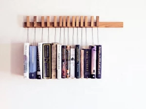 Custom made wooden book rack / bookshelf in Oak. The pins are also bookmarks.