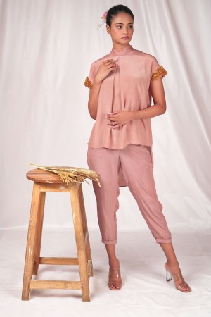 Pink fitted women's trousers with turned up hemline.