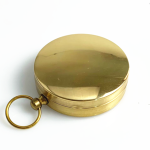 A pure copper flip compass with a key ring and a luminous dial