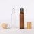 Import Empty bamboo lid clear amber frosted glass roll on perfume bottle with steel roller ball 5ml 10ml 15ml from China