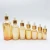 Import good quality 5ml 10ml 15ml 20ml 30ml 50ml 100ml Amber gold glass dropper bottle with wood cap RGB-094T from China