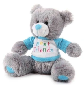 Cuddly soft teddy bear in mocha (light brown) with hand sewn patches to its head and feet and wearing a white T-Shirt.