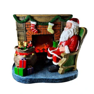 COPYRIGHT Christmas decoration with Santa Clause sits by inserted electrical fireplaces
