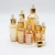 Import good quality 5ml 10ml 15ml 20ml 30ml 50ml 100ml Amber gold glass dropper bottle with wood cap RGB-094T from China