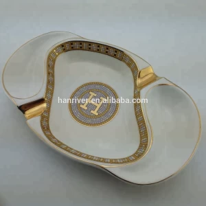 Best selling oval ceramic ashtray with golden edge with two golden rest with customized logo for sale