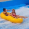 lovely girls played inflatable double riders belly boat surfing simulator for the water park in summer