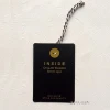 Swing tag factory customizes paper hangtag with debossed silver logo for wide-legged pants